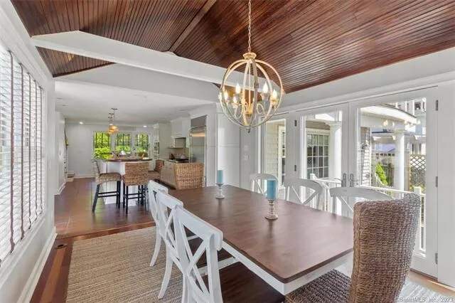 a dining room with furniture a chandelier and wooden floor
