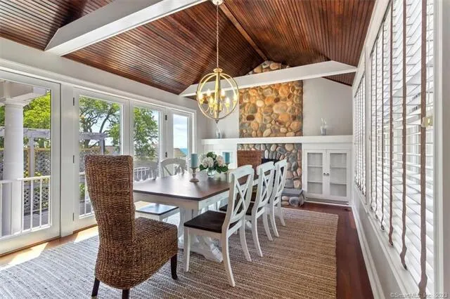 a dining room with furniture large windows and wooden floor