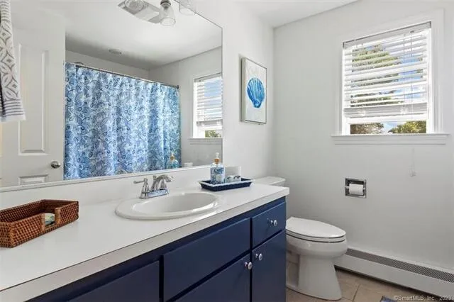 a bathroom with a sink a toilet and a window