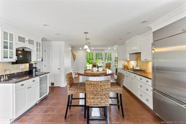 a large kitchen with granite countertop lots of counter space and stainless steel appliances