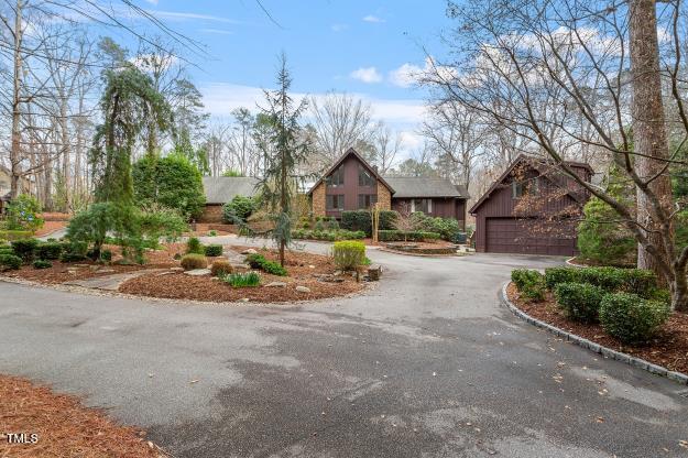 10729 Trego Trail Raleigh, NC 27614 - Photo 4 of 65 A wide circular driveway surrounds an island of spectacular landscaping