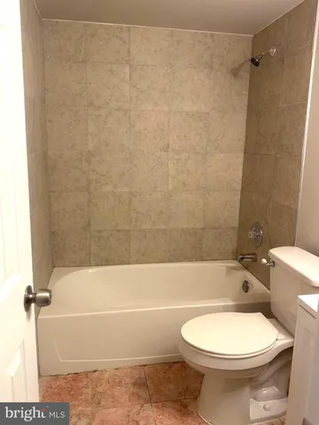a bathroom with a toilet and a bath tub