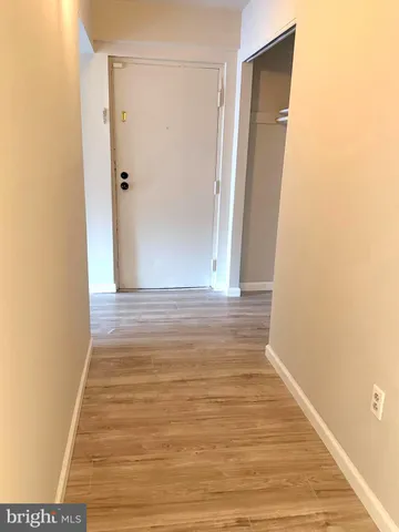 a view of an empty room with wooden floor