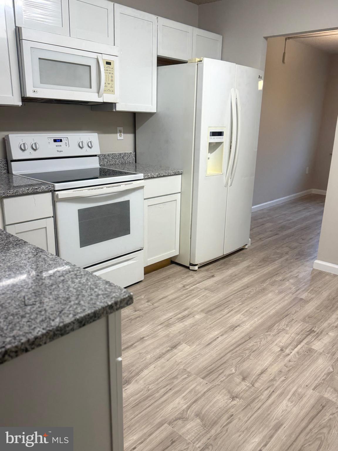 11739 Ledura Court, Unit T7 Reston, VA 20191 - Photo 6 of 17 a kitchen with stainless steel appliances granite countertop a refrigerator sink and white cabinets