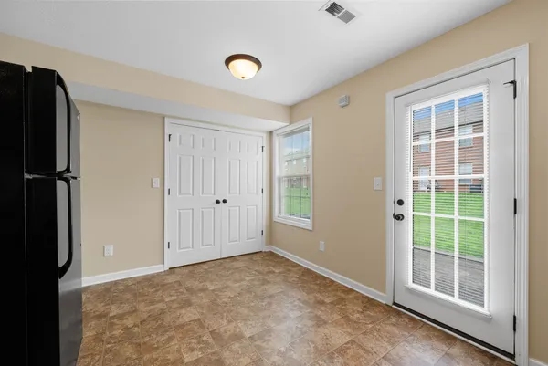 an empty room with windows and chandelier fan