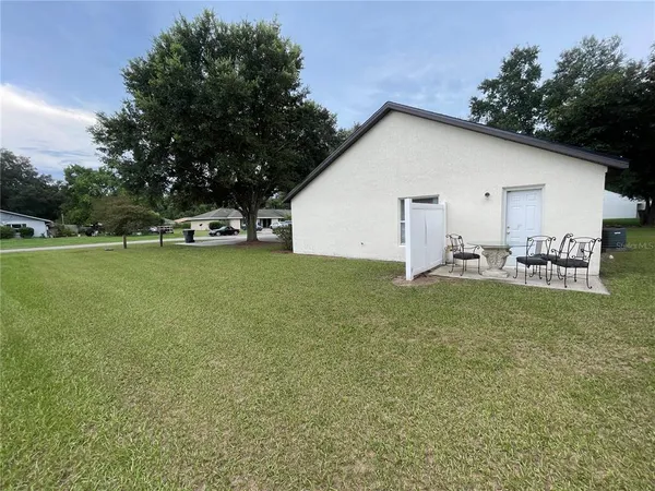 a view of a house with backyard and sitting area