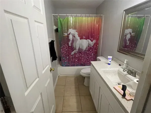 a bathroom with a sink and mirror with bathtub