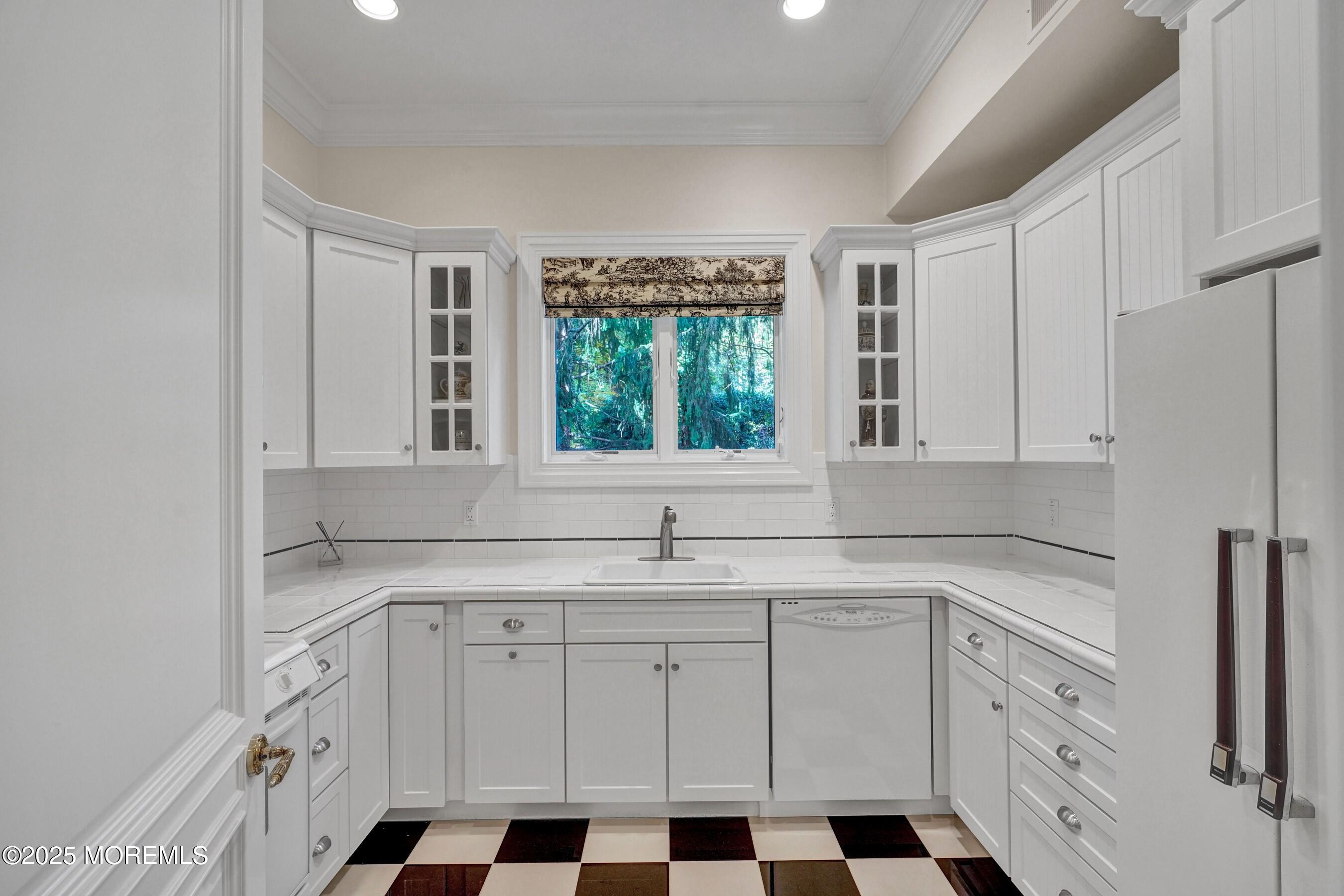 1015 Forrest Road Brielle, NJ 08730 - Photo 47 of 61 a kitchen with white cabinets a sink a window and appliances