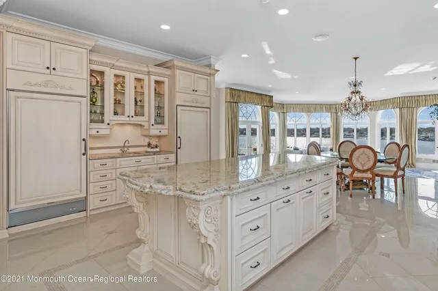 a large white kitchen with lots of counter top space and stainless steel appliances