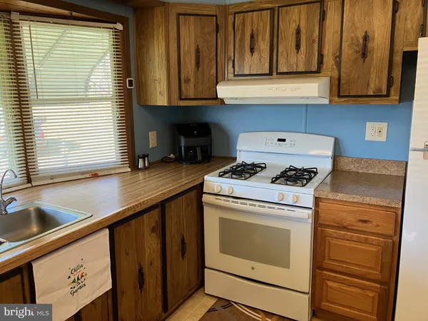 a kitchen with granite countertop cabinets appliances a sink and a window