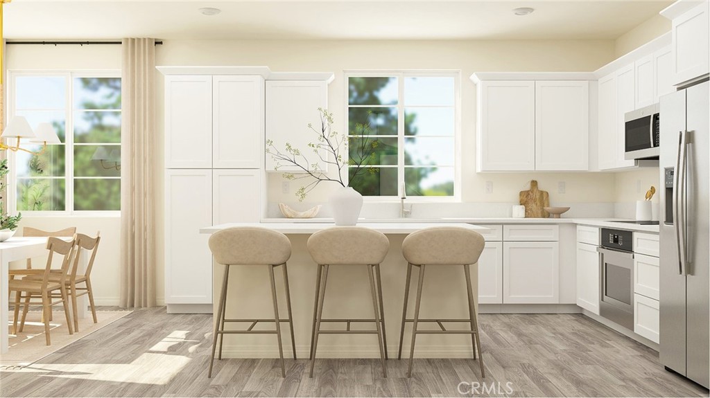 a kitchen with a table chairs refrigerator and cabinets