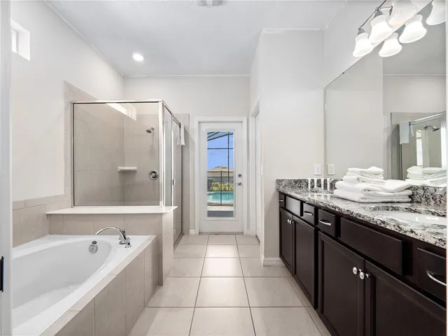 a bathroom with a granite countertop sink a large mirror and a bathtub