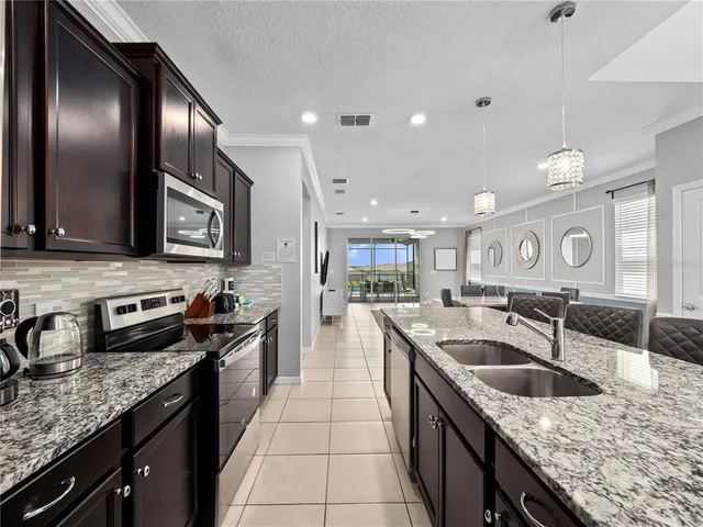 a kitchen with stainless steel appliances granite countertop a sink a stove and a wooden cabinets