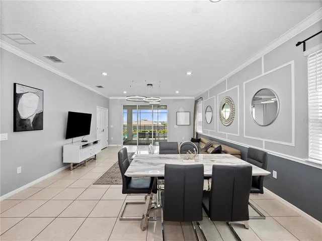 a living room with couches a flat screen tv and kitchen view