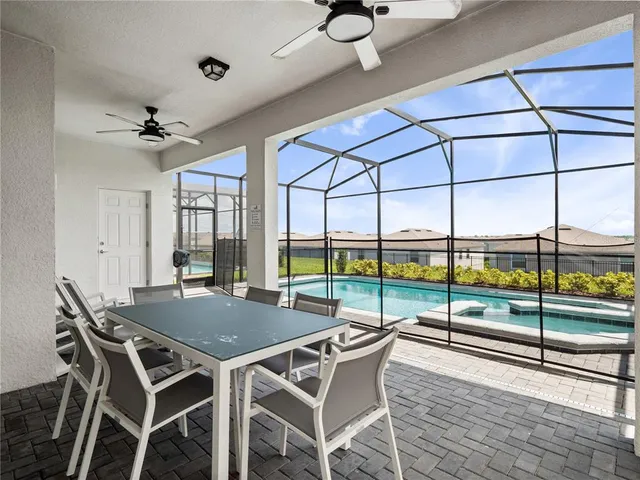 a view of a dining room and livingroom with furniture wooden floor a chandelier