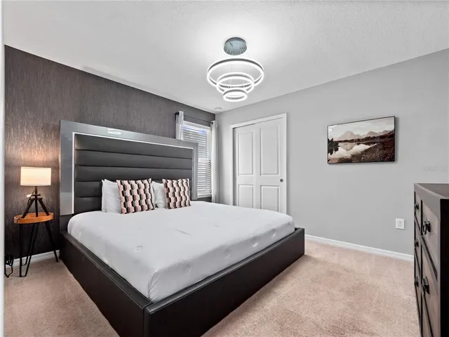 a bedroom with a bed and a chandelier