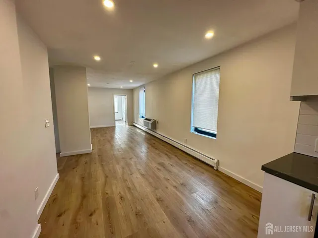 a view of an empty room with wooden floor