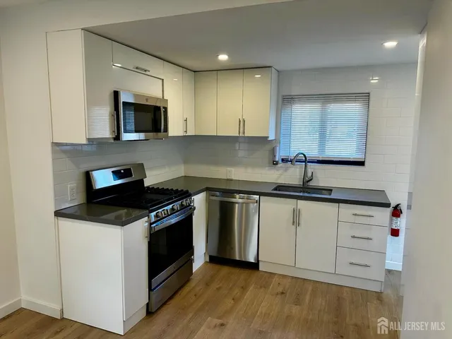 a kitchen with stainless steel appliances granite countertop a sink and a stove