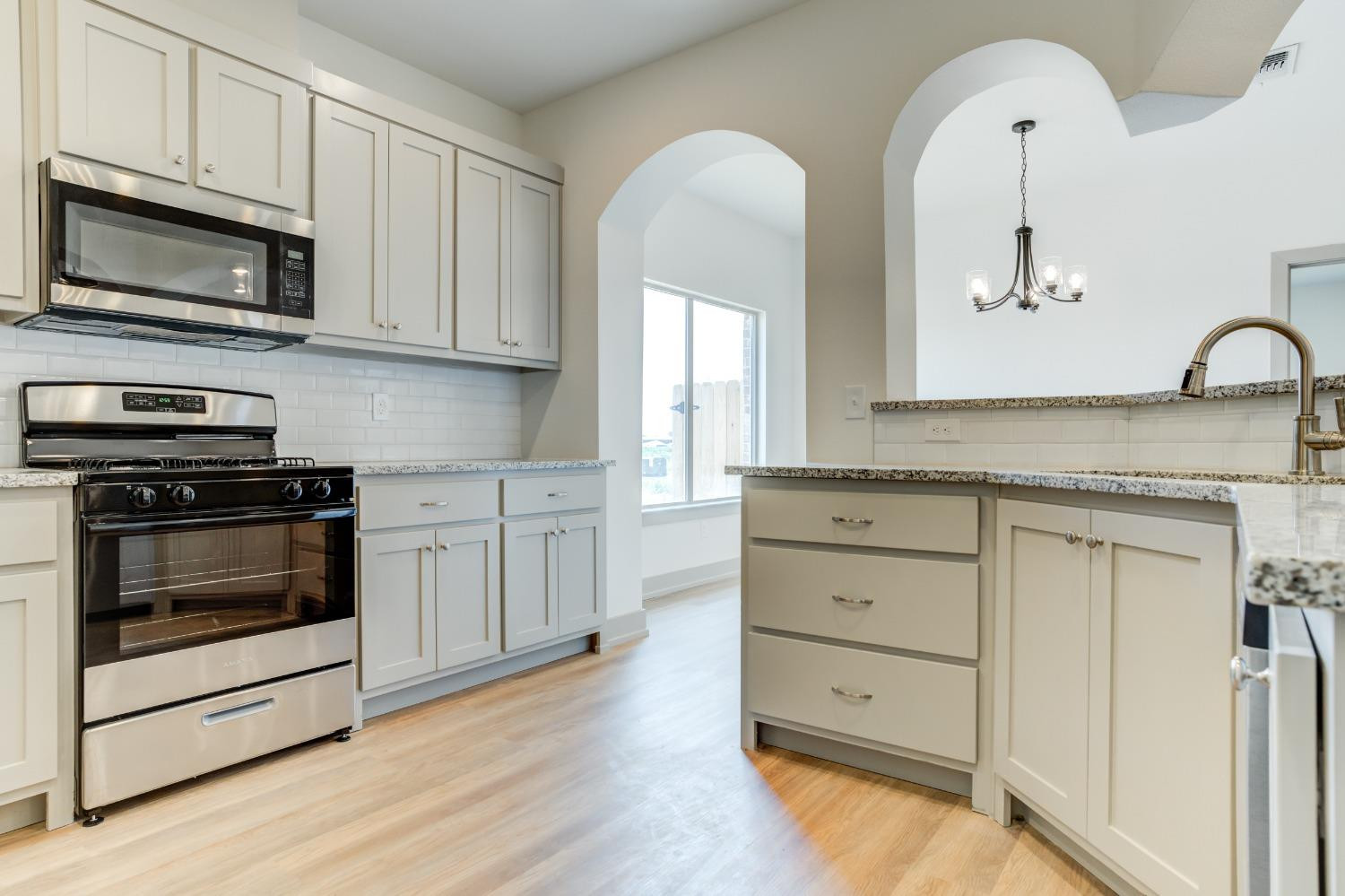 7007 18th Street Lubbock, TX 79416 - Photo 13 of 34 a kitchen with stainless steel appliances white cabinets and a stove a oven with wooden floor