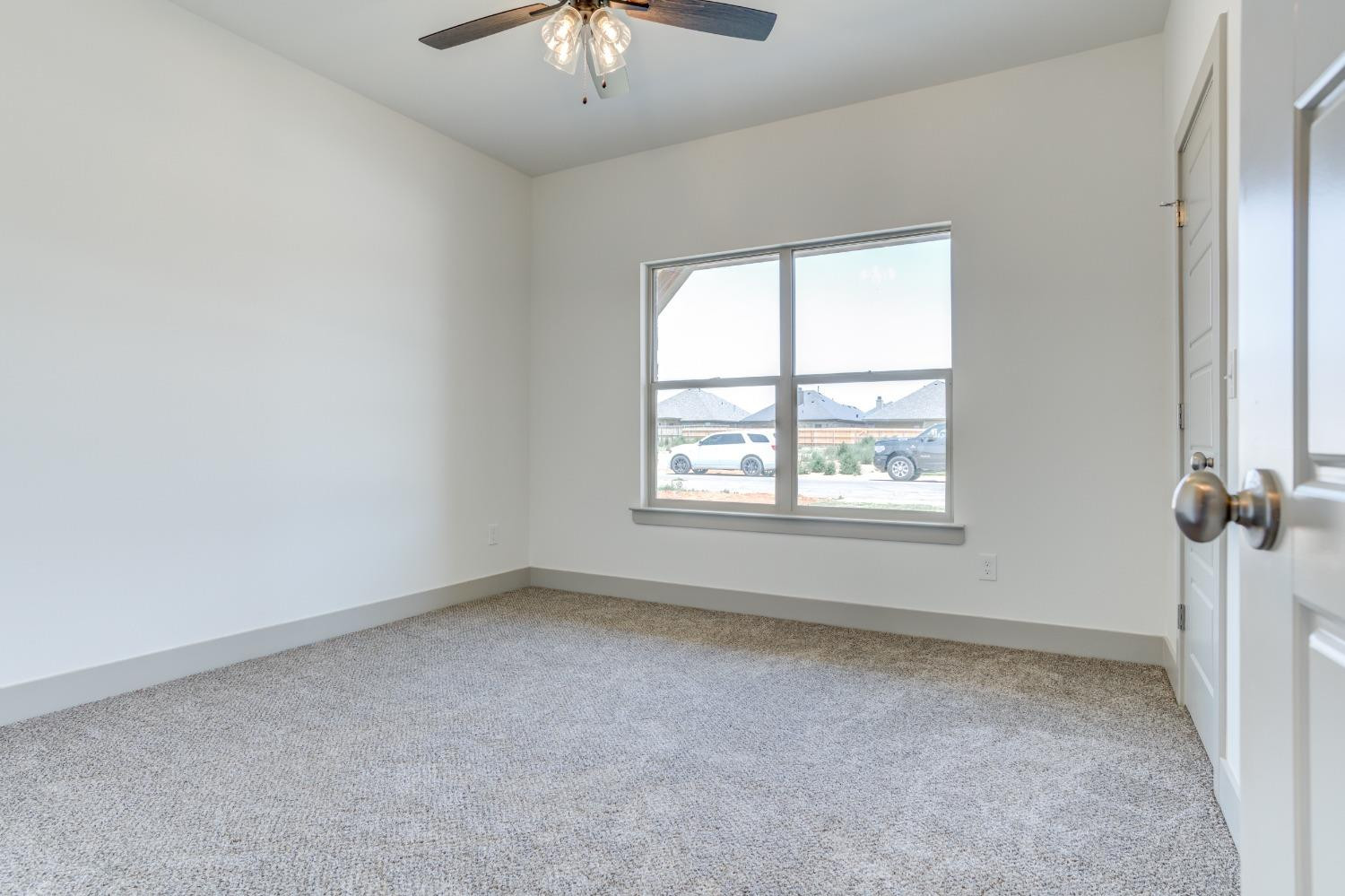 7007 18th Street Lubbock, TX 79416 - Photo 18 of 34 an empty room with a chandelier fan and windows