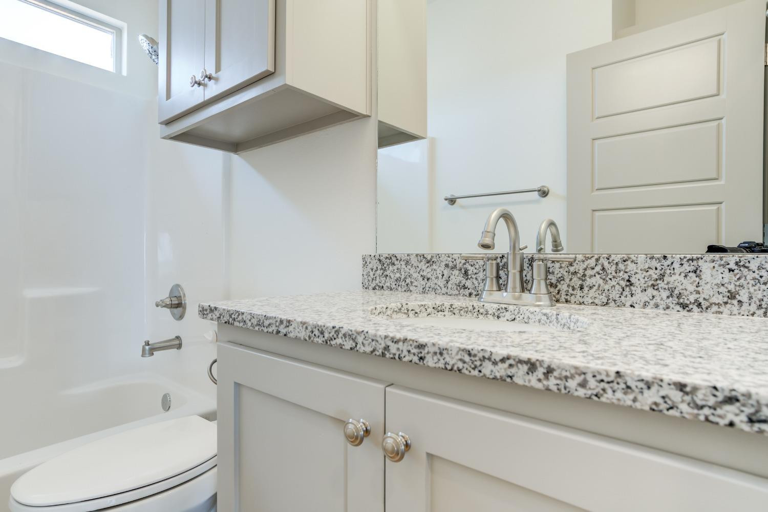 7007 18th Street Lubbock, TX 79416 - Photo 21 of 34 a bathroom with a granite countertop sink and a mirror
