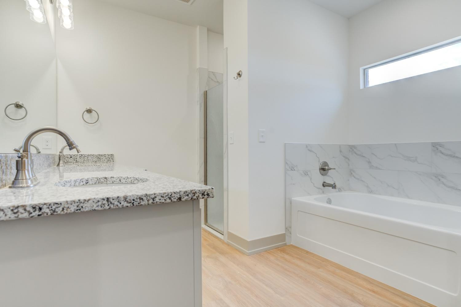 7007 18th Street Lubbock, TX 79416 - Photo 27 of 34 a bathroom with a granite countertop sink and a mirror