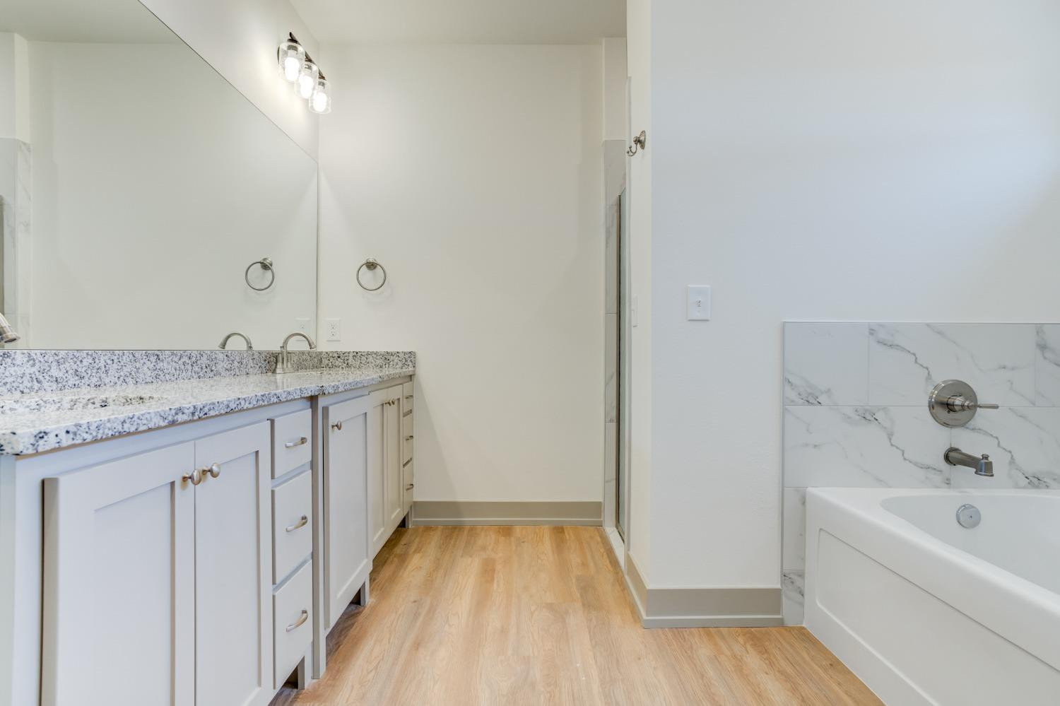 7007 18th Street Lubbock, TX 79416 - Photo 28 of 34 a bathroom with a granite countertop sink and a bathtub