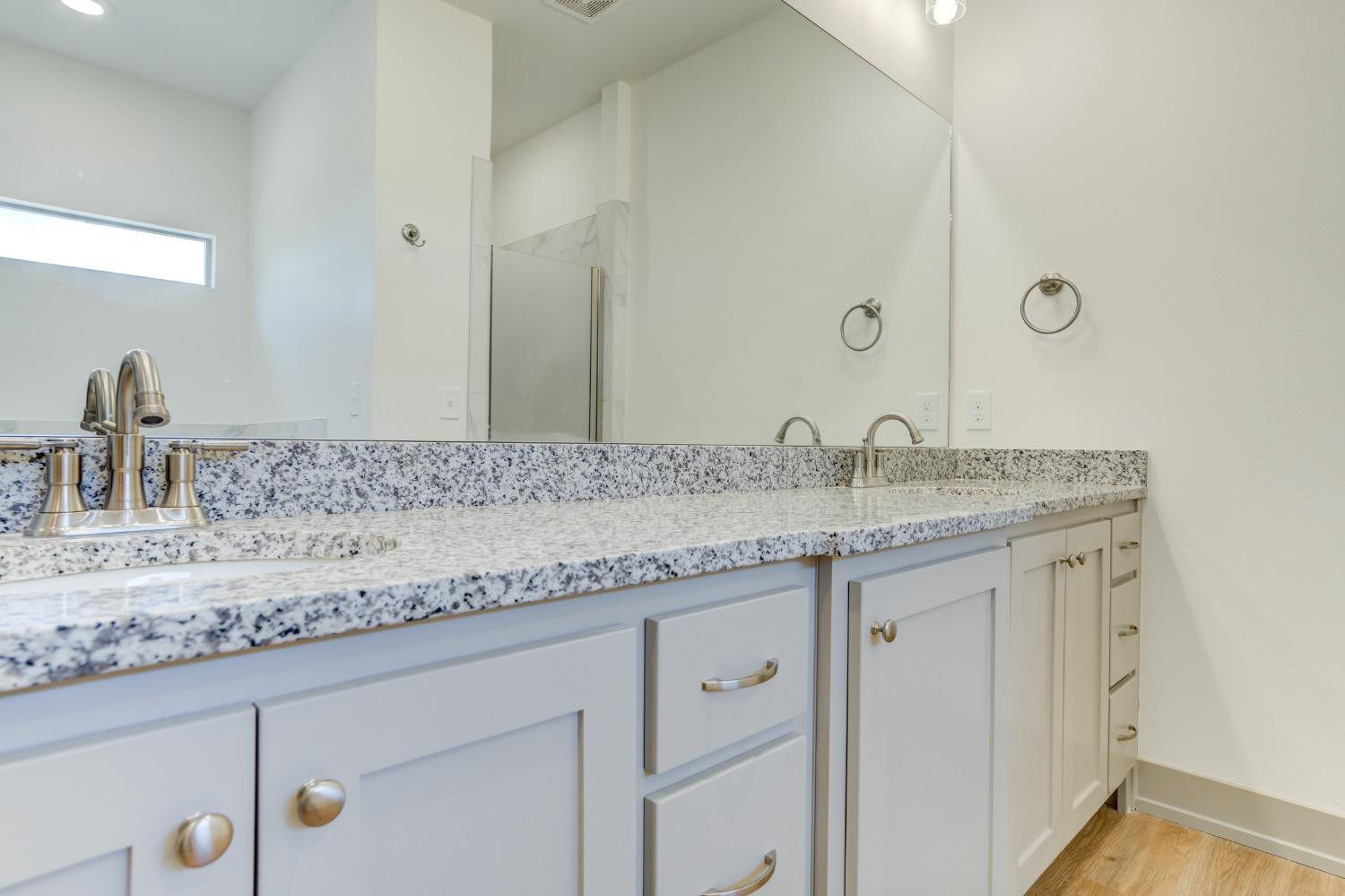 7007 18th Street Lubbock, TX 79416 - Photo 29 of 34 a bathroom with a granite countertop sink and a mirror