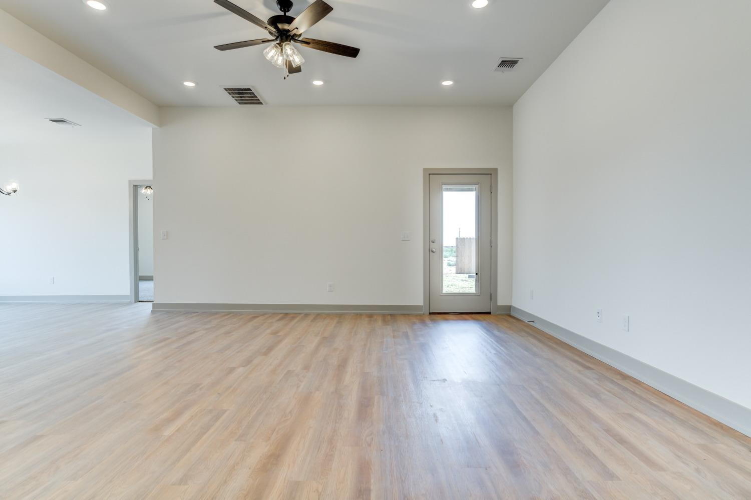 7007 18th Street Lubbock, TX 79416 - Photo 5 of 34 an empty room with wooden floor and windows