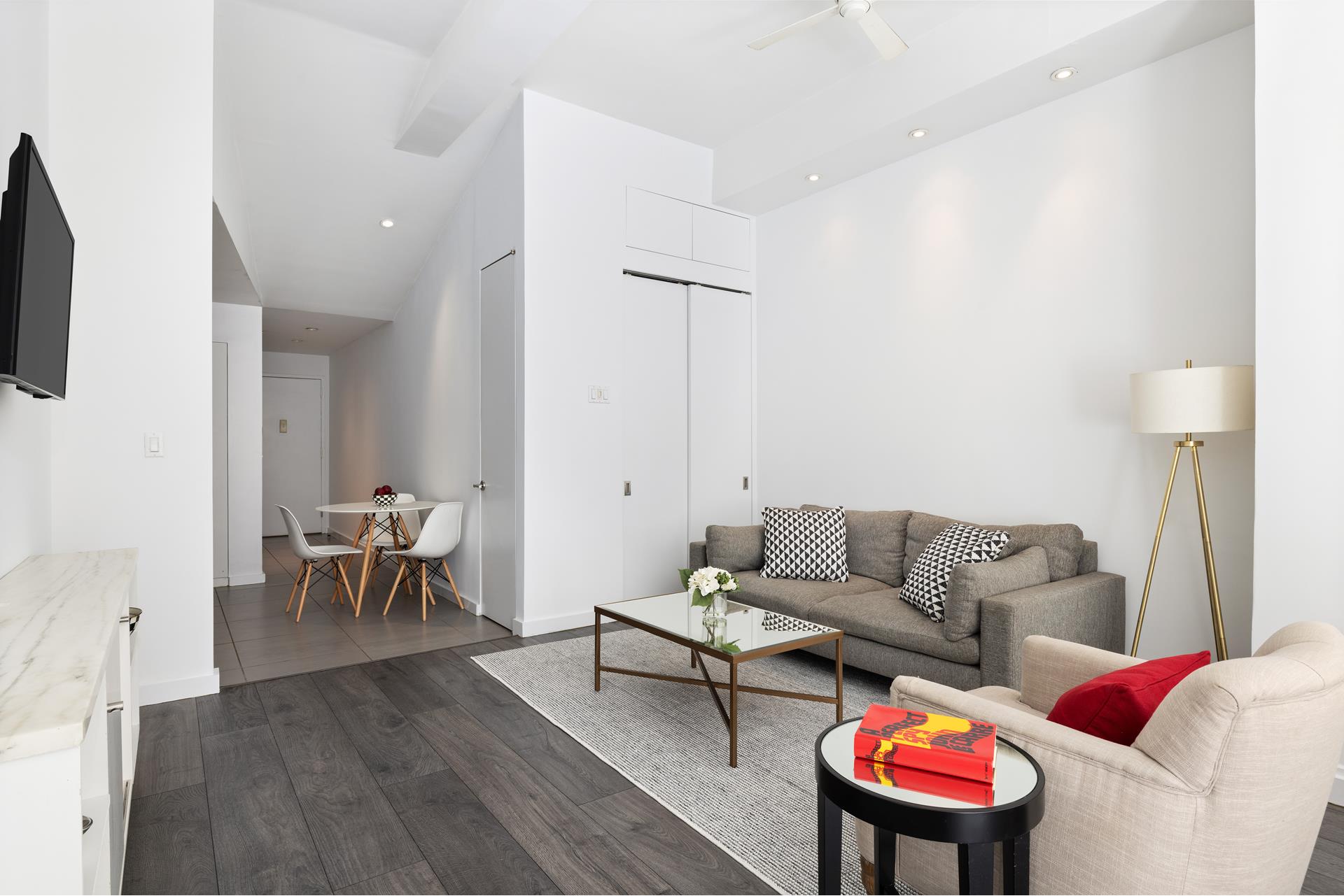 3 Hanover Square, Unit 9G Manhattan, NY 10004 - Photo 7 of 10 a living room with furniture and a wooden floor