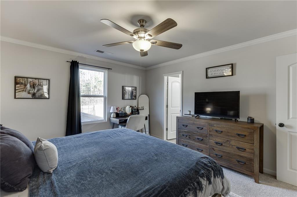 565 Bryson Trail Monroe, GA 30655 - Photo 27 of 43 a bedroom with a bed and a flat screen tv on dresser