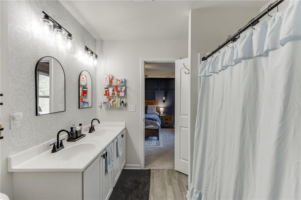 565 Bryson Trail Monroe, GA 30655 - Photo 31 of 43 a en suite bathroom with a double vanity sink and a mirror
