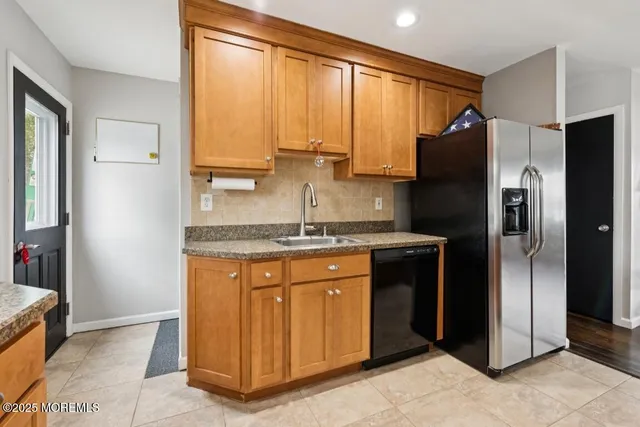 a kitchen with stainless steel appliances granite countertop a refrigerator and a sink