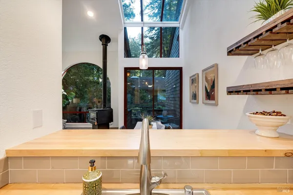 a kitchen with a sink a stove and chairs with wooden floor