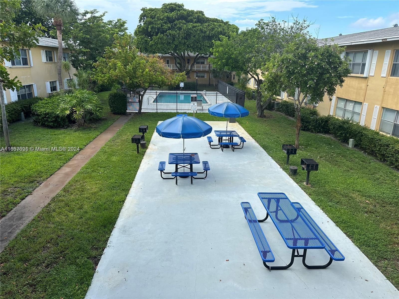 Sequoia Gardens Condominiums Deerfield Beach, FL 33441 - Photo 23 of 25 a view of a backyard with table and chairs and a garden