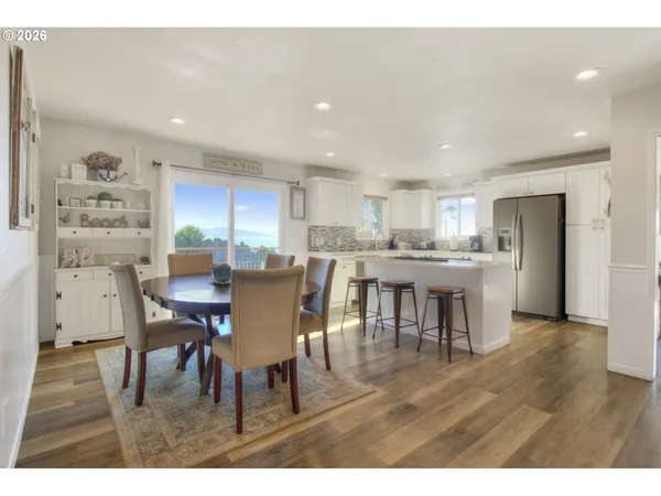 a kitchen with a dining table chairs and refrigerator