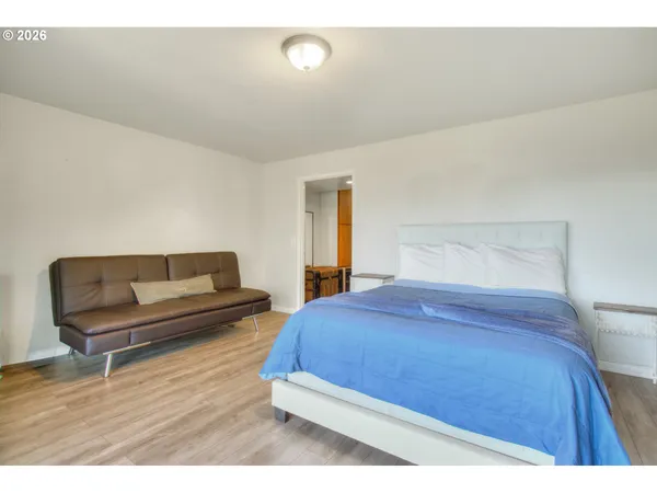 a bedroom with a bed and a wooden floor