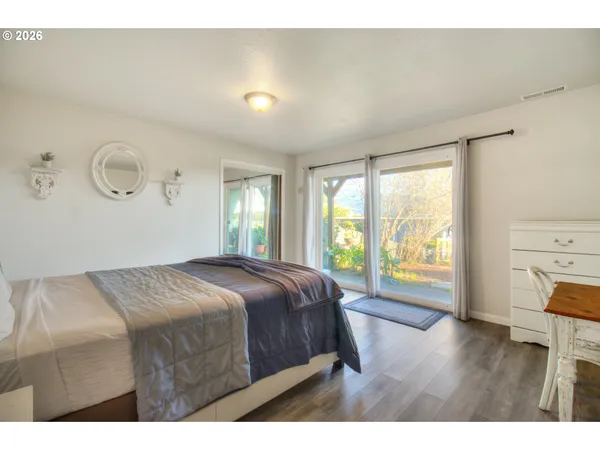 a bedroom with a bed and a wooden floor