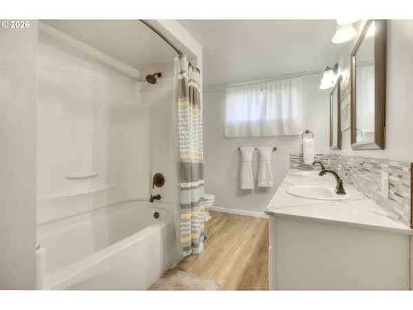 a bathroom with a sink double vanity mirror and a bathtub