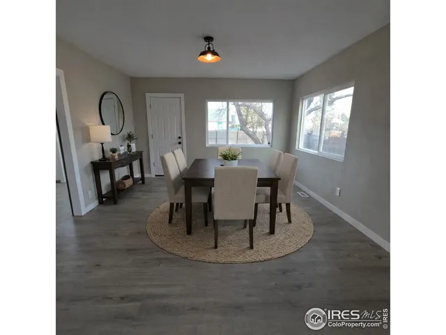 a dining room with wooden floor a glass table and chairs