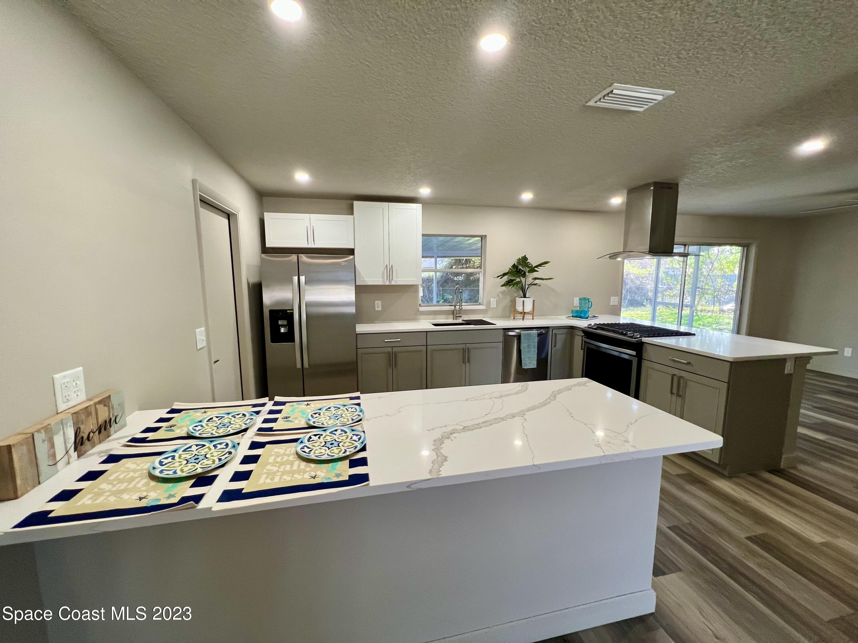 1095 Coronado Drive Rockledge, FL 32955 - Photo 7 of 28 a large kitchen with kitchen island a sink stove and refrigerator