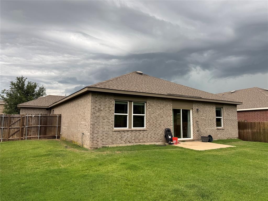 2209 Cinnamon Spgs Road Glenn Heights, TX 75154 - Photo 27 of 28 Rear exterior featuring a brick facade, sliding glass patio door, and a concrete patio pad
