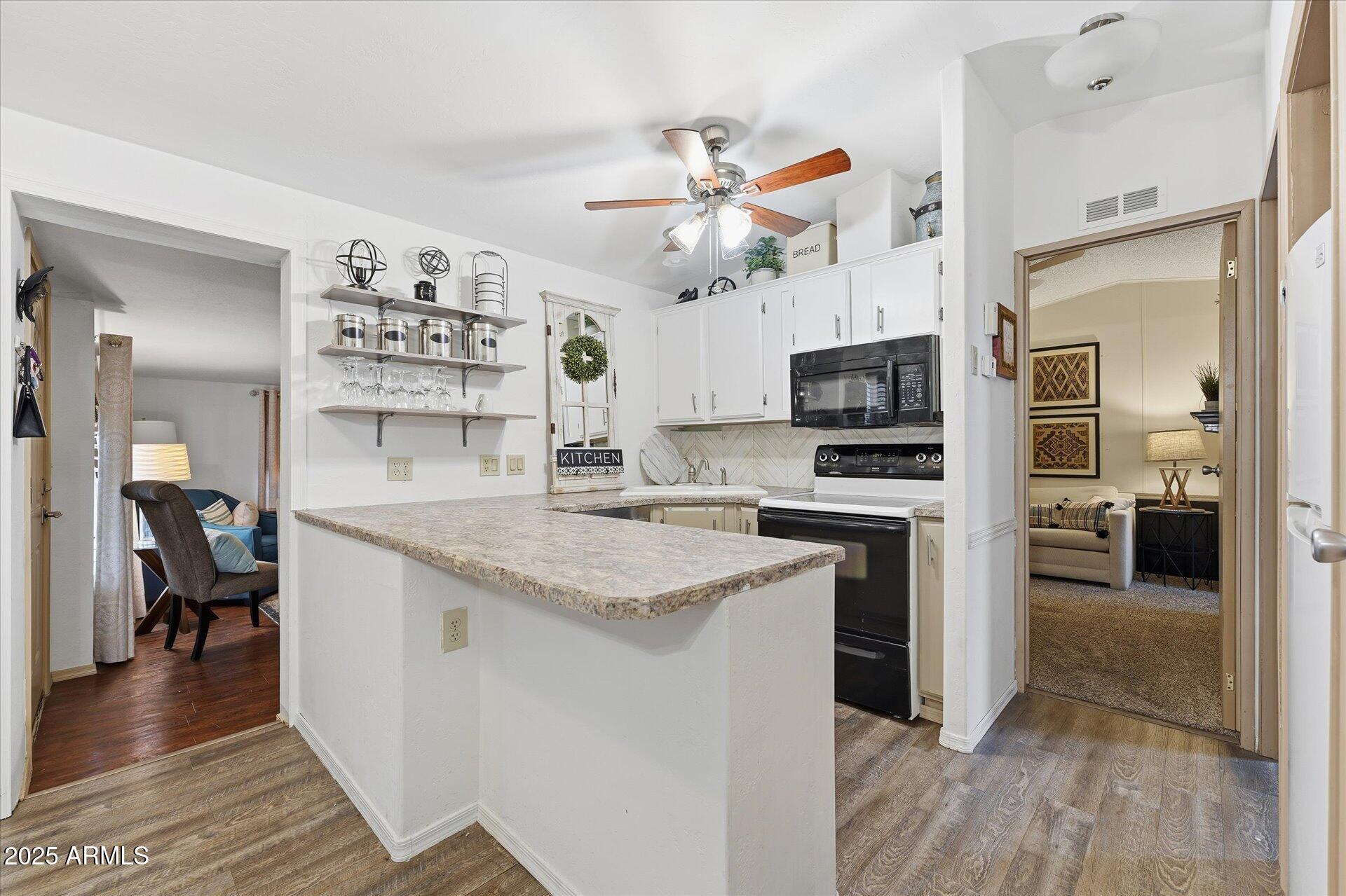 5735 East McDowell Road, Unit 243 Mesa, AZ 85215 - Photo 11 of 42 a kitchen with granite countertop a stove a sink and a refrigerator