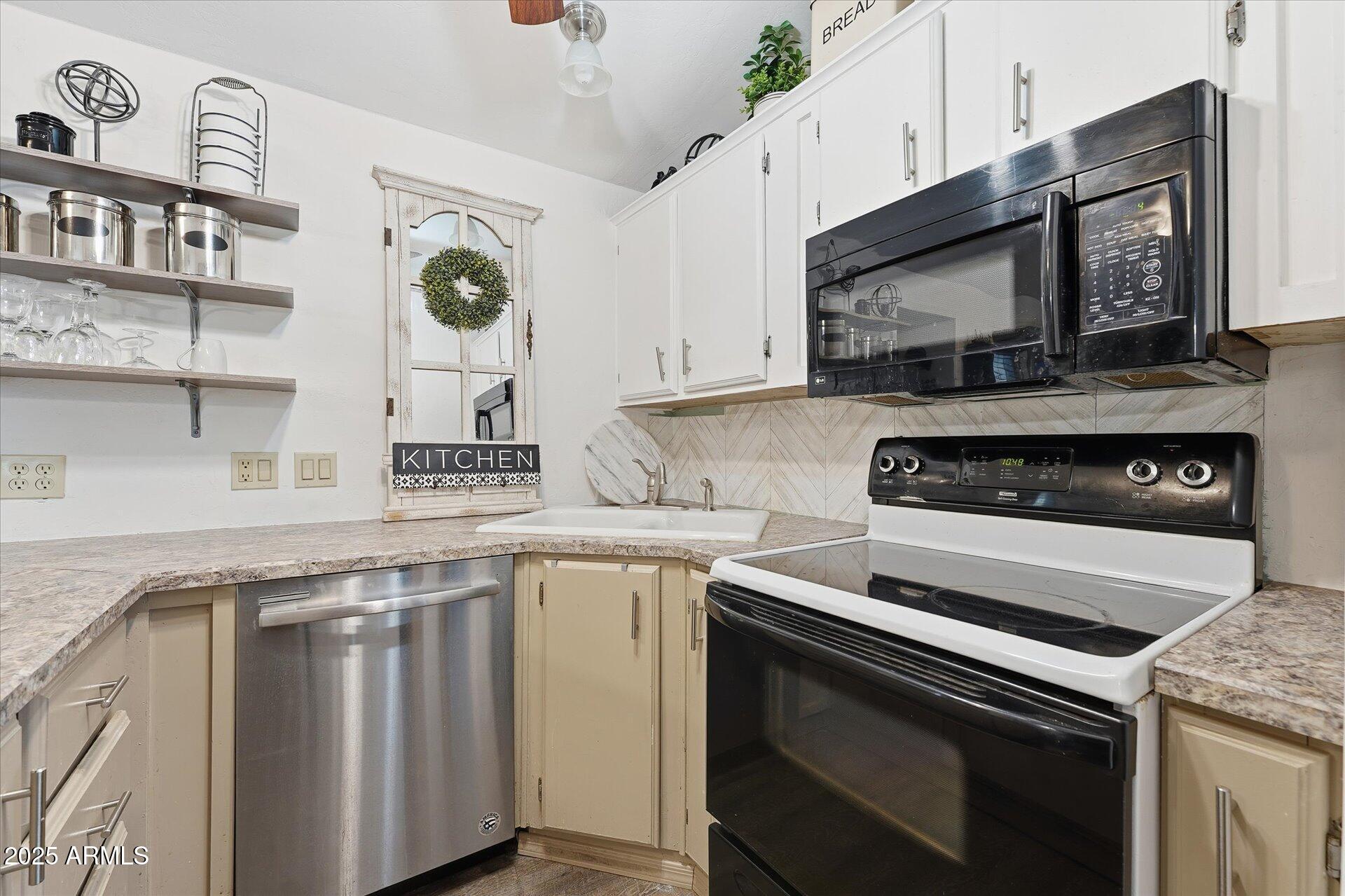 5735 East McDowell Road, Unit 243 Mesa, AZ 85215 - Photo 13 of 42 a kitchen with stainless steel appliances granite countertop a stove microwave and sink