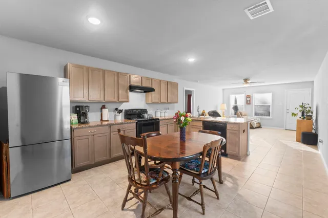 a kitchen with a dining table chairs refrigerator and cabinets
