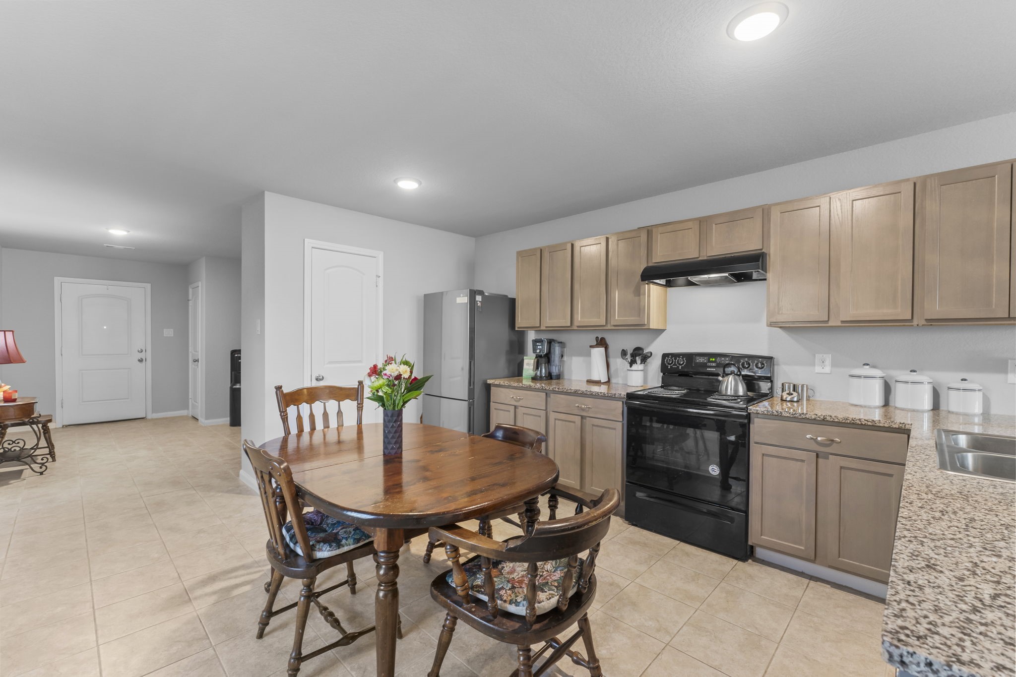 15120 Arrowhead Loop East Willis, TX 77378 - Photo 7 of 22 a kitchen with stainless steel appliances a dining table chairs refrigerator and cabinets