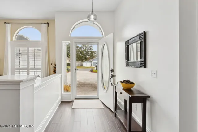 a living room with furniture a window and wooden floor