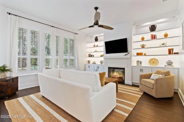 a living room with furniture a flat screen tv and a fireplace