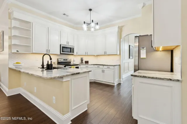 a kitchen with white cabinets and stainless steel appliances