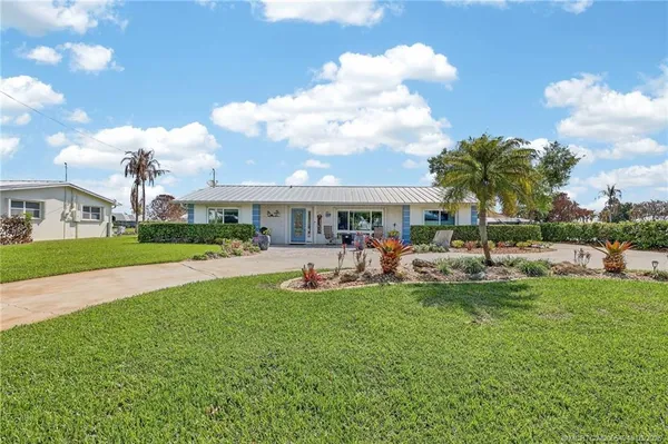 a view of a house with a big yard and a large trees with wooden fence